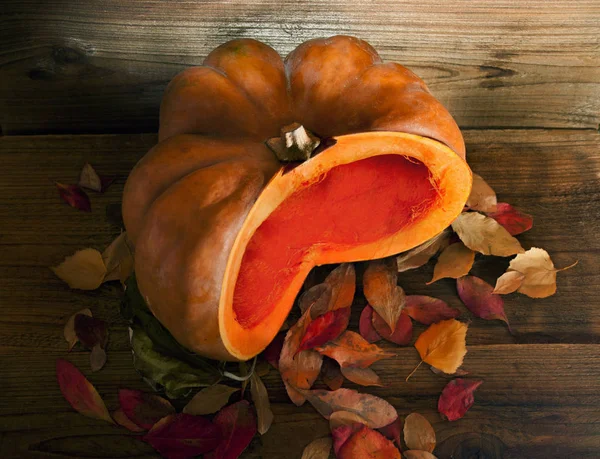 Cut orange pumpkin on a wooden background — Stock Photo, Image