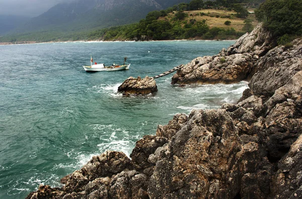 Piccola nave vicino alla costa rocciosa — Foto Stock