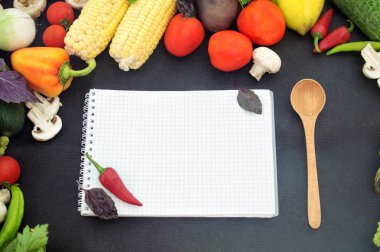 Kağıt, tahta kaşık, taze sebze ile siyah arka plan üzerine