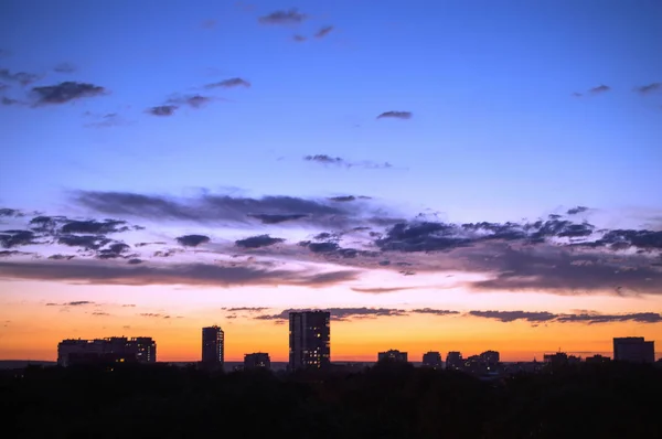 Pôr do sol e nuvens no céu contra o pano de fundo do hig urbano — Fotografia de Stock