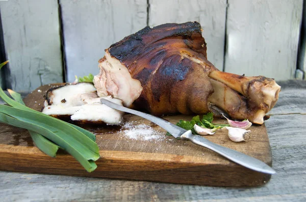 Gebackenes Fleisch auf einem Holzbrett mit Gewürzen und Kräutern — Stockfoto