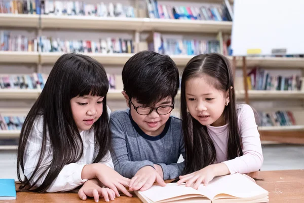 Groep Kinderen Lezen Boek Met Geïnteresseerd Gevoel Bibliotheek Wazig Licht — Stockfoto