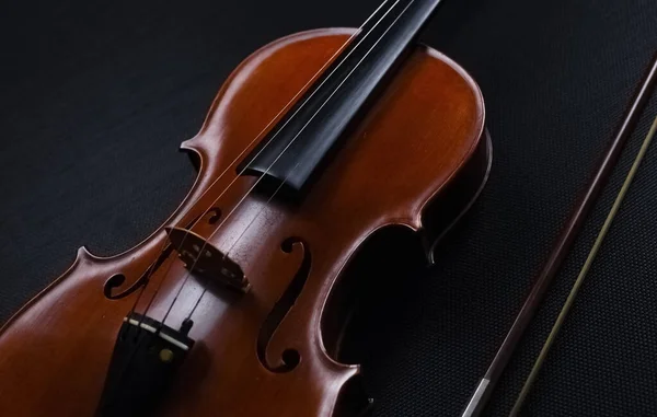 木制小提琴的抽象艺术设计背景放在背景上 展示弦乐器的正面 在黑色帆布背景上 — 图库照片