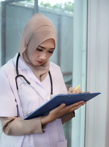 Femme Musulmane Médecin Écrivant Sur Dossier Patient Travaillant Hôpital Avec — Photo