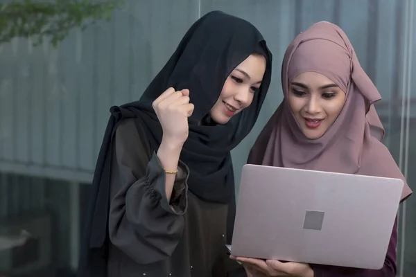 Två Muslimska Kvinnor Arbetar Med Laptop Tillsammans Med Glad Känsla — Stockfoto