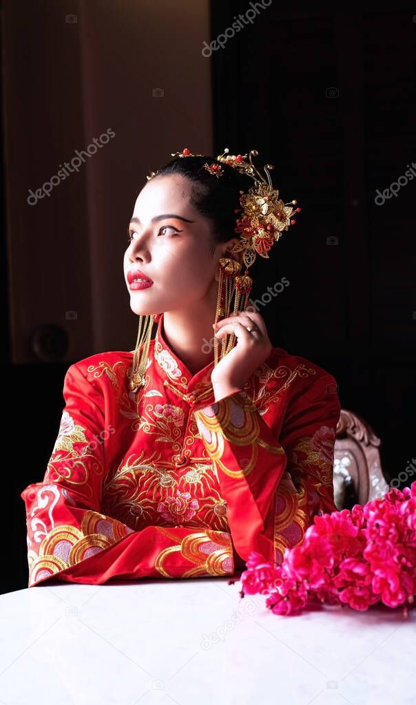 The beautiful woman wearing red suit,turn face up looking outside,portrait of model posing on chinese New year festival