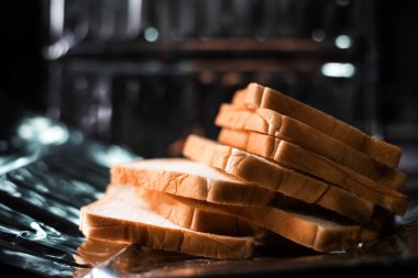 Alüminyum tepside dilimlenmiş ekmek, bulanık ışık...