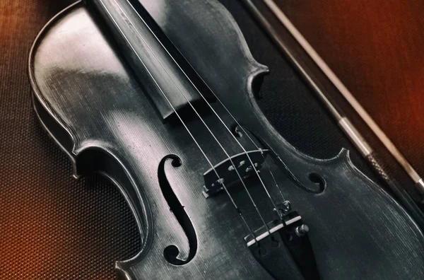 ヴァイオリン フロント サイドの抽象的なアート デザインの背景は ぼやけた弓の横に 黒いキャンバスに ぼやけた光の周りに置かれている — ストック写真