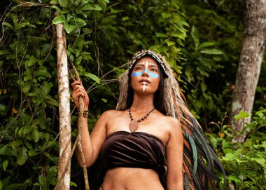 Güzel bayan boyalı yüz ve vücut kahverengi ve mavi renkli, elini kaldır boynuna dokun, modelin portresi etrafında bulanık ışık