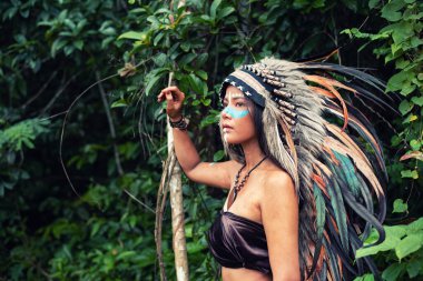 Güzel bayan boyalı yüz ve vücut kahverengi ve mavi renkli, elini kaldır boynuna dokun, modelin portresi etrafında bulanık ışık