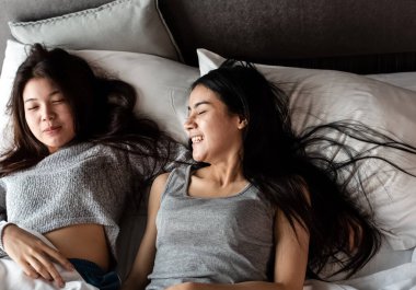İki güzel kadın yatağa uzanıp sohbet ediyorlar. Romantik bir duygu, aşk çifti, iyi bir arkadaşlık, oda arkadaşı.