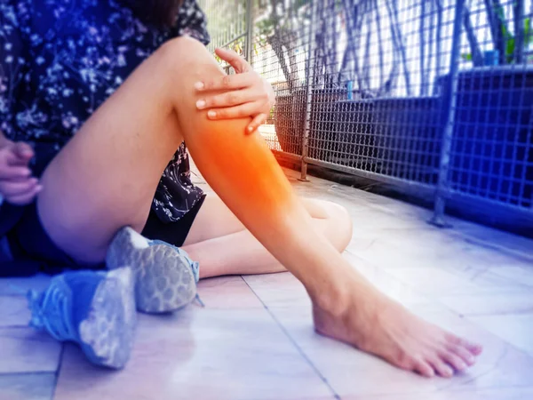 女性の足の選択的な焦点で手で触れました 周りオレンジの円を持ちます あなたの下の足の内側に沿って新しいの症状 痛みや痛みを分割します 運動中 周りのぼやけた光 — ストック写真