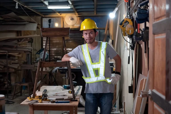 Knappe Man Met Gele Helm Handschoen Naast Een Houten Stoel — Stockfoto