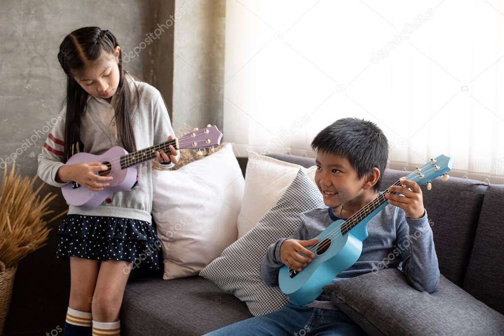 Two children playing ukulele together,with happy feeling,at home studio,beside window,blurry light around