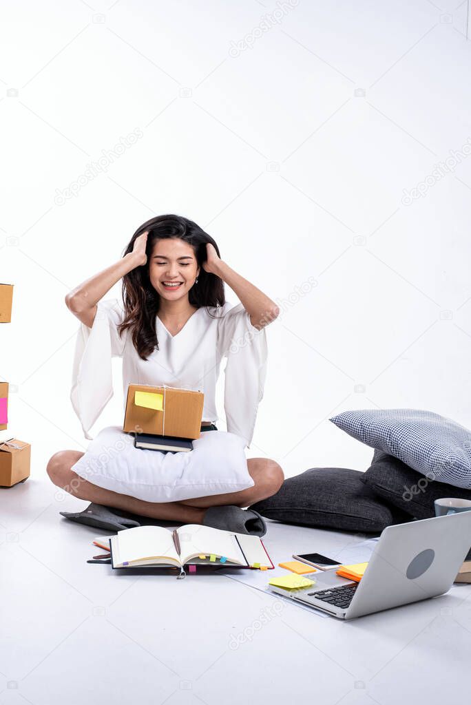 The beautiful lady sitting on floor,raise hand touch her head with happy feeling,checking order and packing post box,selling online at home