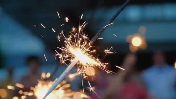 Sparklers close up, orange lights fall on all sides. Bright burning wand of bengal light, spark super slow motion. Christmas, New Year celebration — Stockvideo