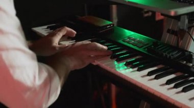 Male hands play music on the piano at a concert. Playing the electronic piano close-up. The musician pianist plays jazz on the piano. A man touches the keys with his fingers.