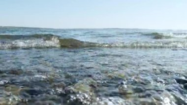 Sea waves on the shore, close-up. Clear water in the sea, natural marine oceanic background. Dawn sunrise sunset at sea ocean. Summer vacation relaxation concept. The rays of the sun.
