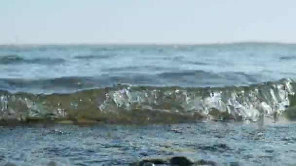 Clear water in the sea, the concept of rest relax, summer vacation. Natural sea oceanic background. The rays of the sun, sea waves on the shore close-up. — Stockvideo