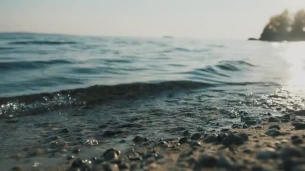 Água limpa no mar, fundo oceânico marinho natural. Os raios do sol, ondas do mar na costa close-up. Pôr-do-sol amanhecer no mar. Verão conceito de relaxamento de férias. — Vídeo de Stock