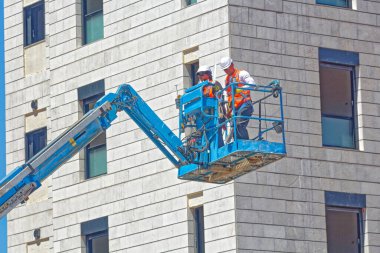 Bir inşaat işçisi vinç kamyonlarıyla çalışıyor..
