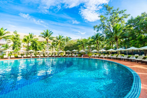 Guarda-chuvas e cadeiras em torno da piscina — Fotografia de Stock