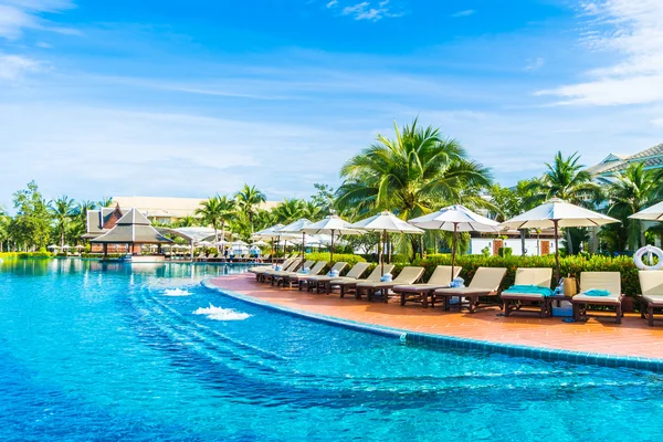 Umbrellas and chairs around swimming pool — Stock Photo, Image