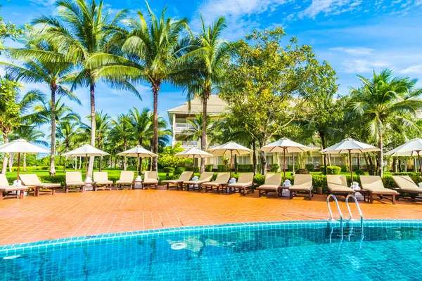 Guarda-chuvas e cadeiras em torno da piscina — Fotografia de Stock