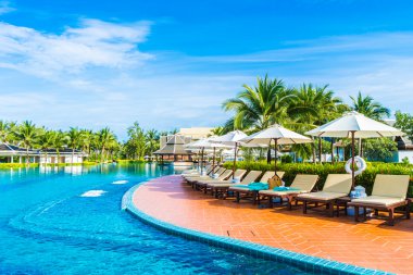 Şemsiyeleri ve sandalyeler Yüzme Havuzu etrafında 