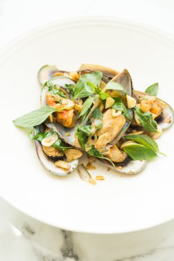 Kızarmış midye fesleğen yaprakları ile