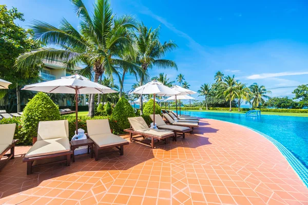 Paraguas y silla alrededor de la piscina — Foto de Stock