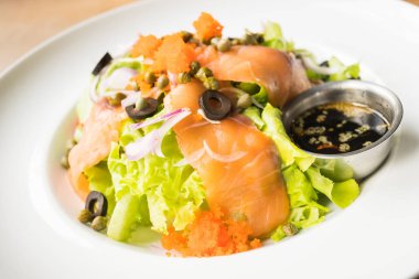 Beyaz tabak içinde somon salata