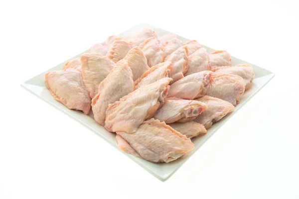Сырое куриное мясо и крылышко в белой тарелке — стоковое фото