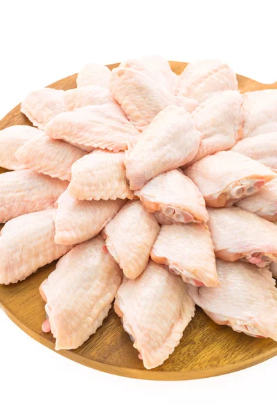 Carne de pollo cruda y ala en tabla de cortar o placa de madera — Foto de Stock