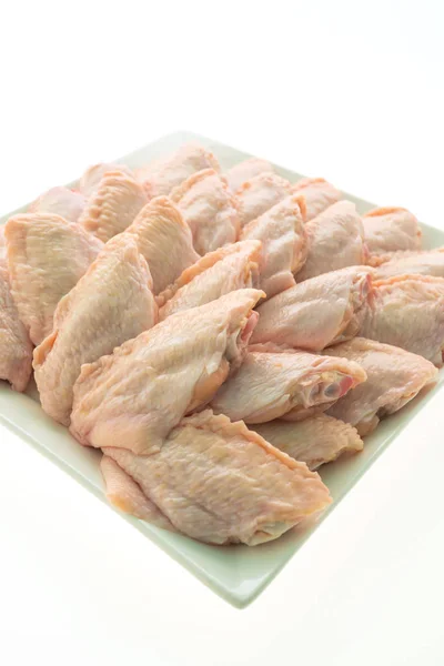 Carne crua de frango e asa em placa branca — Fotografia de Stock