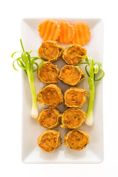 Derin kızarmış yengeç eti rulo beyaz tabak içinde