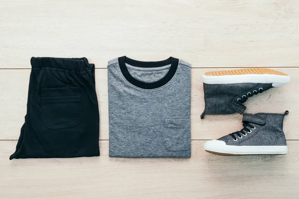 T-shirt med byxor och skor på trä bakgrund — Stockfoto