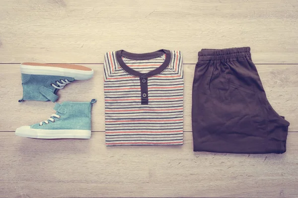T-shirt pantolon ve ahşap arka plan üzerinde ayakkabı ile — Stok fotoğraf