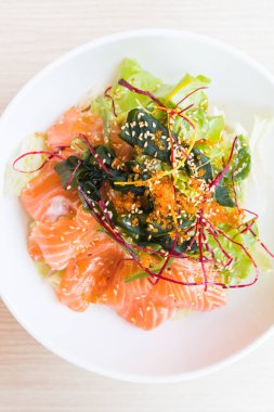 Beyaz tabak içinde somon salata 