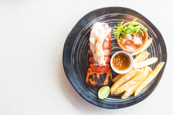 Steak de homard en assiette noire — Photo