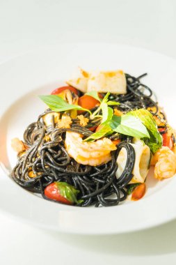Deniz ürünleri beyaz tabak içinde siyah spagetti