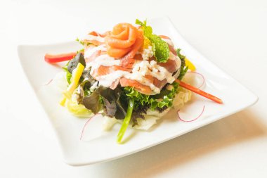 Beyaz tabak içinde somon salata