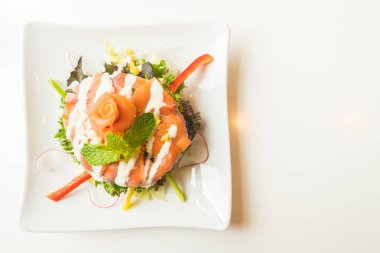 Beyaz tabak içinde somon salata 