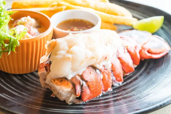 Lobster steak in black plate — Stock Photo, Image