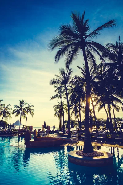 Silhouette palma da cocco intorno alla piscina — Foto Stock