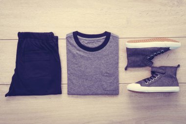 T-shirt pantolon ve ahşap arka plan üzerinde ayakkabı ile