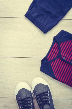 T-shirt pantolon ve ahşap arka plan üzerinde ayakkabı ile