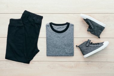 T-shirt pantolon ve ahşap arka plan üzerinde ayakkabı ile