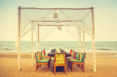 Masa ve sandalye sahilde akşam yemeği için ayarla