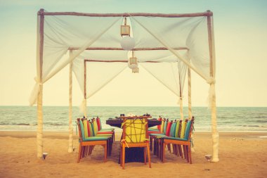 Masa ve sandalye kumsalda akşam yemeği için ayarla